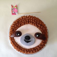 a cake decorated to look like a slotty face with brown hair and two eyes