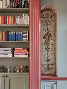 the bookshelves in this room are painted pink and have decorative designs on them