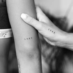 two people with tattoos on their arms holding onto each other's arm and the word love is written across them