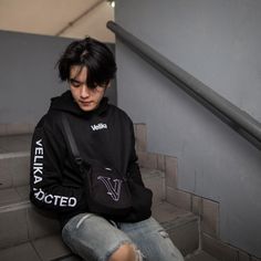 a young man sitting on the stairs with his backpack