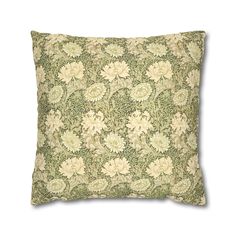 a green and white pillow with flowers on it