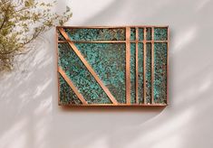 a piece of art that is made out of copper and green pattered with paint