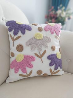 a white couch with a flowered pillow on it