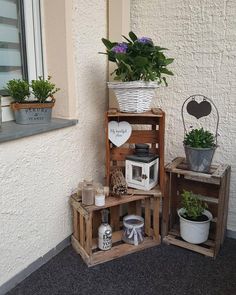 three wooden crates with plants in them sitting on the side of a building next to a window