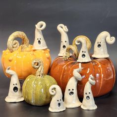 five ceramic pumpkins with faces on them