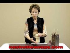 a woman is cutting paper with a knife on a table in front of a bag