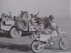 an old black and white photo of men riding on the back of a truck with soldiers in it