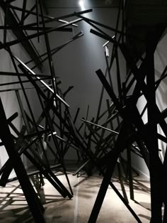 an abstract sculpture is shown in black and white with light coming from the ceiling behind it