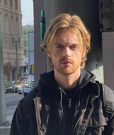 a man standing on the street with his hand in his pocket