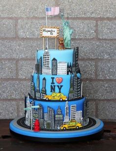 a three tiered cake decorated with the statue of liberty and new york on top