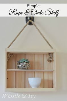 simple rope and crate shelf with white bowl on top, hanging from the wall above it