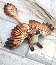 a wooden bird with intricate designs on it's wings