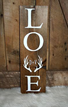 a wooden sign that says love with antlers on it