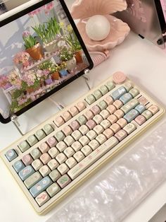 a computer keyboard sitting on top of a table next to a flower potted plant