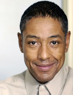 a close up of a person wearing a shirt and tie with a smile on his face