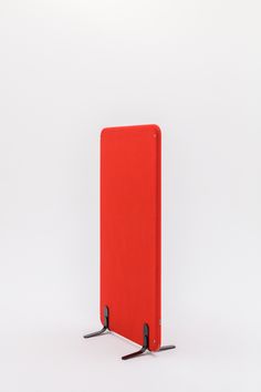 a red piece of luggage sitting on top of a white floor next to two black handles