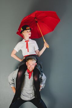 a man riding on the back of a woman in tights and heels holding an umbrella