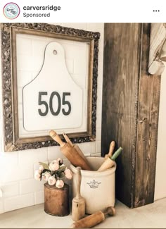 there is a sign on the wall above some kitchen utensils and a potted plant