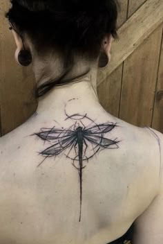 a woman with a dragonfly tattoo on her back