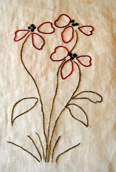 a close up of a piece of cloth with embroidery on it and flowers in the middle