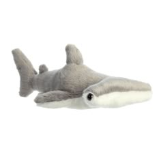 a stuffed shark laying on top of a white surface