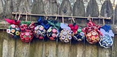 several ornaments are hanging on a wooden fence