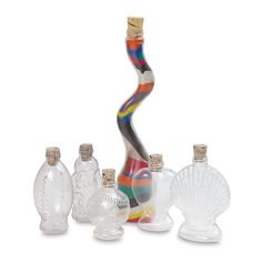 an assortment of glass bottles and vases on a white background, including one with a spiral design