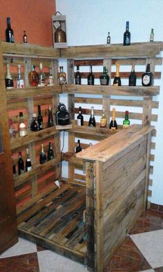 a room with shelves made out of wooden pallets and bottles on the top shelf