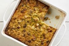 a casserole dish with broccoli and cheese in it on a white table