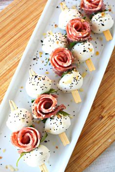 small appetizers are arranged on a plate with toothpicks and black pepper