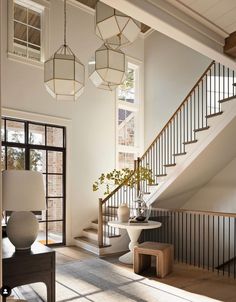 a living room filled with furniture next to a stair case covered in lamps and vases