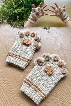 two crocheted mittens with flowers on them sitting on top of a wooden table