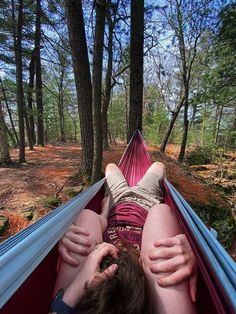 a person laying in a hammock with their feet on the ground