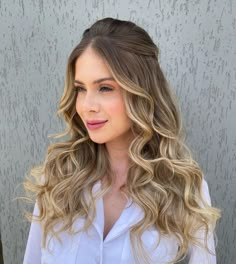 a woman with long blonde hair wearing a white shirt