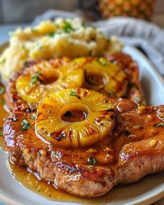 pineapple and pork chops with mashed potatoes on a plate