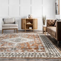 a living room with two couches and a rug on the floor in front of a white wall