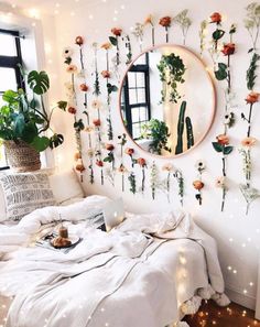 a bedroom decorated with flowers and plants on the wall, along with a round mirror