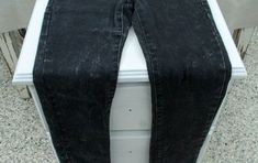 a pair of black jeans sitting on top of a white counter next to a window