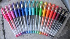 many different colored pens are lined up in a row on the ground, one is empty