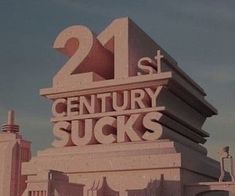 the 21st century sucks sign is displayed on top of a building in front of other buildings