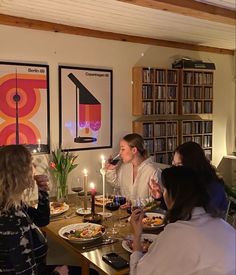 a group of people sitting around a table with food and drinks in front of them