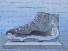 the air jordan 11 glitter is on display in front of a brick wall