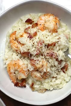 a white bowl filled with pasta and shrimp