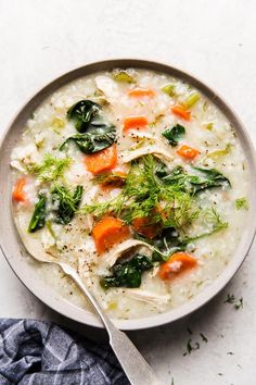 a bowl of chicken and rice soup with carrots, celery and parsley