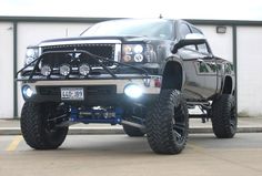 a large truck parked in front of a building with lights on it's headlights