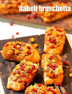 some food is sitting on a wooden board and ready to be eaten with the words dabeli bruschetta above it