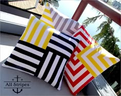 three colorful pillows sitting on top of a wooden chair next to each other, with the words all stripes written across them