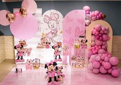 there are many pink balloons and minnie mouses on the floor in front of them