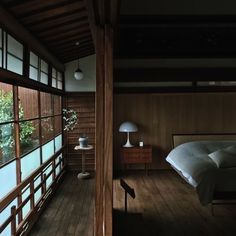 a bedroom with wood flooring and large windows