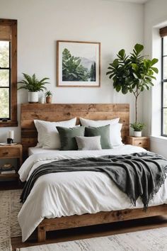 a bed with white sheets and pillows in a bedroom next to two plants on the wall